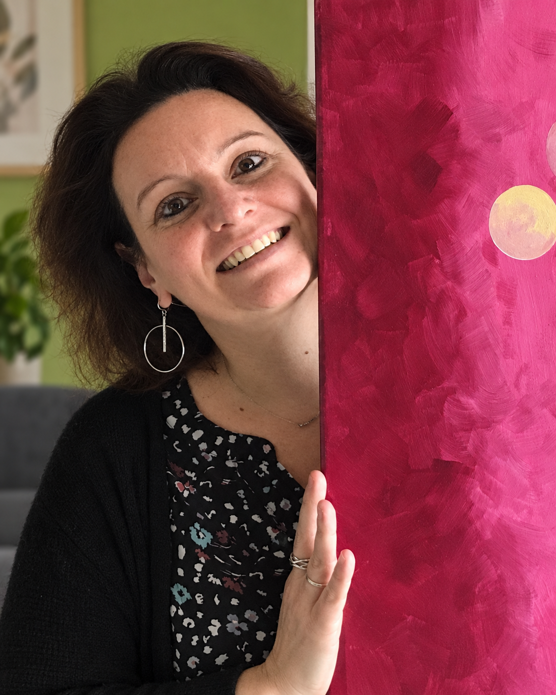 Béa souriante auprès de l’une de ses peintures